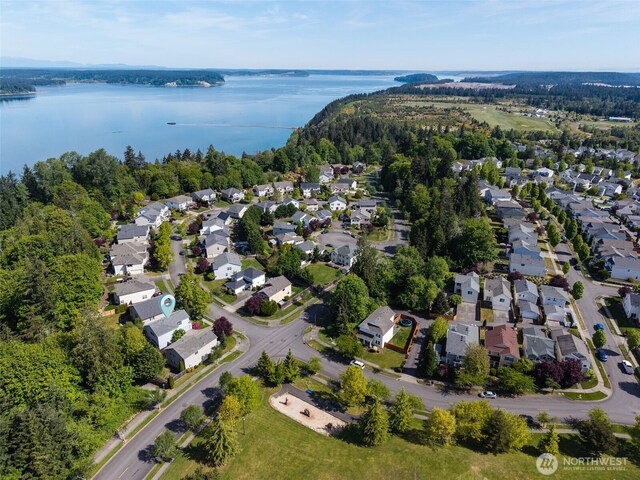 aerial view of property's location with a nearby body of water and nearby suburban area