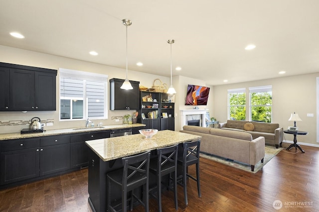 18709 138th Street Ct E, Bonney Lake, WA 98391 - kitchen featuring a sink, a kitchen bar, a kitchen island, a fireplace, and dishwashing machine