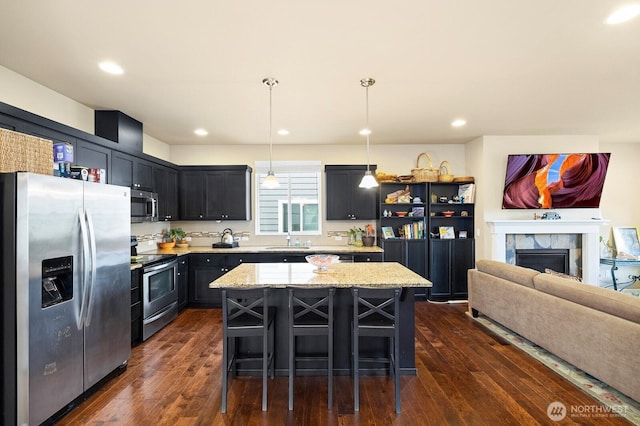 18709 138th Street Ct E, Bonney Lake, WA 98391 - kitchen featuring stainless steel appliances, dark wood-style floors, a kitchen island, light stone countertops, and a sink
