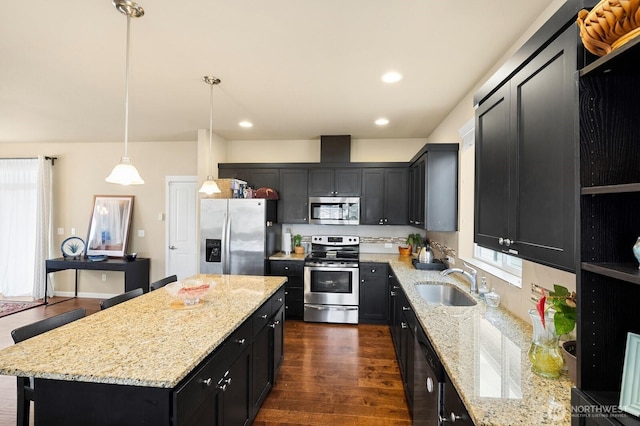 18709 138th Street Ct E, Bonney Lake, WA 98391 - kitchen featuring appliances with stainless steel finishes, a sink, dark cabinets, a kitchen island, and decorative light fixtures