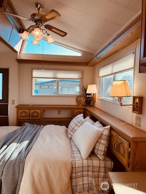 bedroom with vaulted ceiling and multiple windows