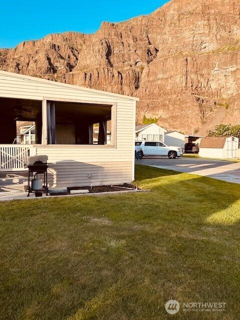 view of home's exterior with a mountain view and a yard