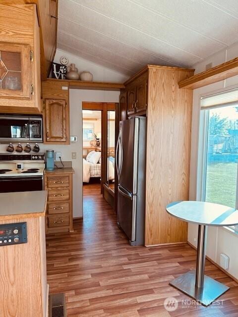 kitchen featuring visible vents, light wood-style floors, light countertops, vaulted ceiling, and stainless steel appliances