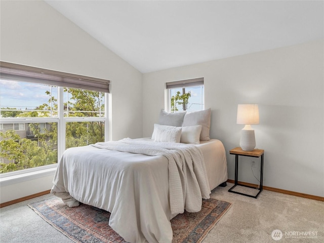 carpeted bedroom with lofted ceiling and baseboards
