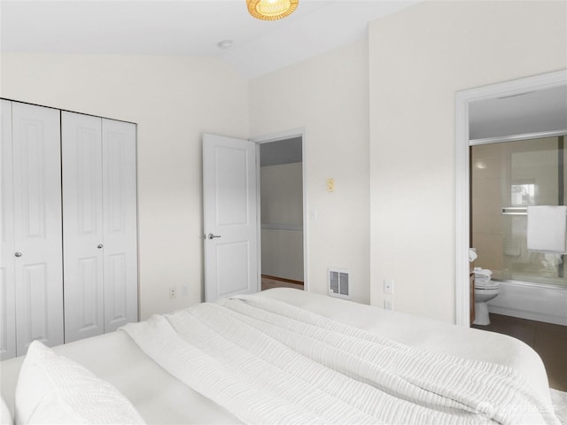 bedroom featuring vaulted ceiling, a closet, and connected bathroom