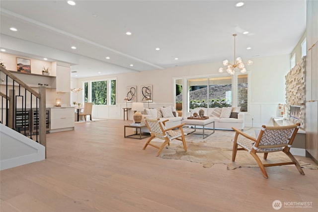 living area with a wainscoted wall, light wood finished floors, a chandelier, a decorative wall, and recessed lighting