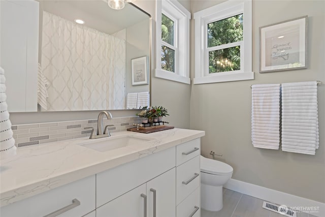 full bathroom featuring visible vents, baseboards, toilet, and vanity