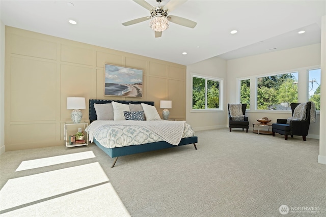 bedroom with recessed lighting, light colored carpet, and a decorative wall