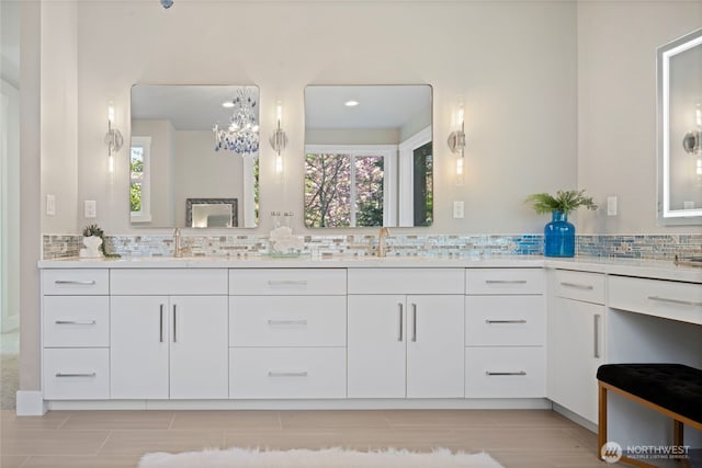 bathroom featuring double vanity, decorative backsplash, and a sink