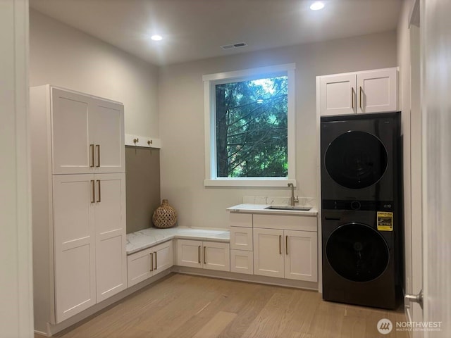 955 103rd Ave SE, Bellevue, WA 98004 - washroom with stacked washer and clothes dryer, cabinet space, light wood-type flooring, and recessed lighting