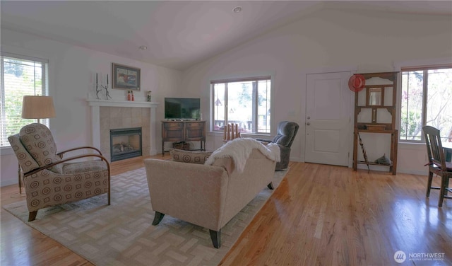 2078 11th St, Port Townsend, WA 98368 - living area featuring vaulted ceiling, healthy amount of natural light, light wood-type flooring, and a tiled fireplace