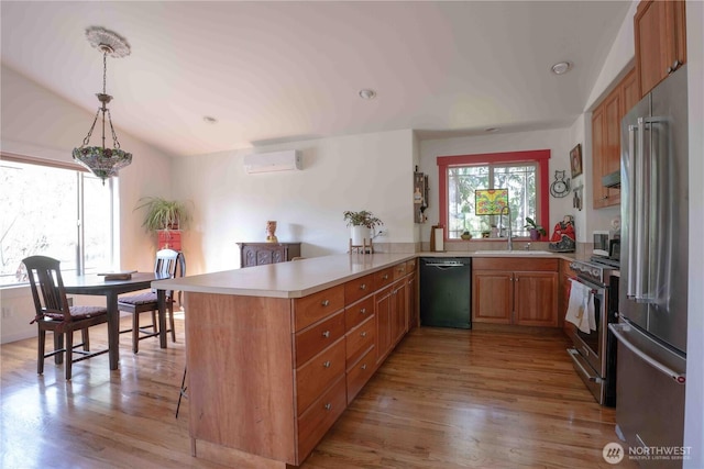 2078 11th St, Port Townsend, WA 98368 - kitchen featuring stainless steel appliances, a peninsula, a sink, a wall unit AC, and light countertops