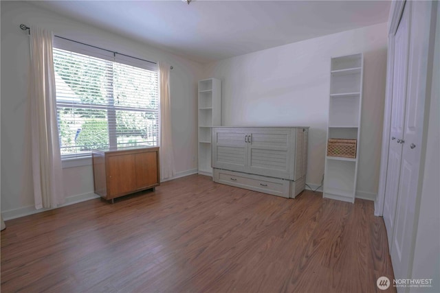 2078 11th St, Port Townsend, WA 98368 - unfurnished bedroom featuring wood finished floors, multiple windows, and baseboards
