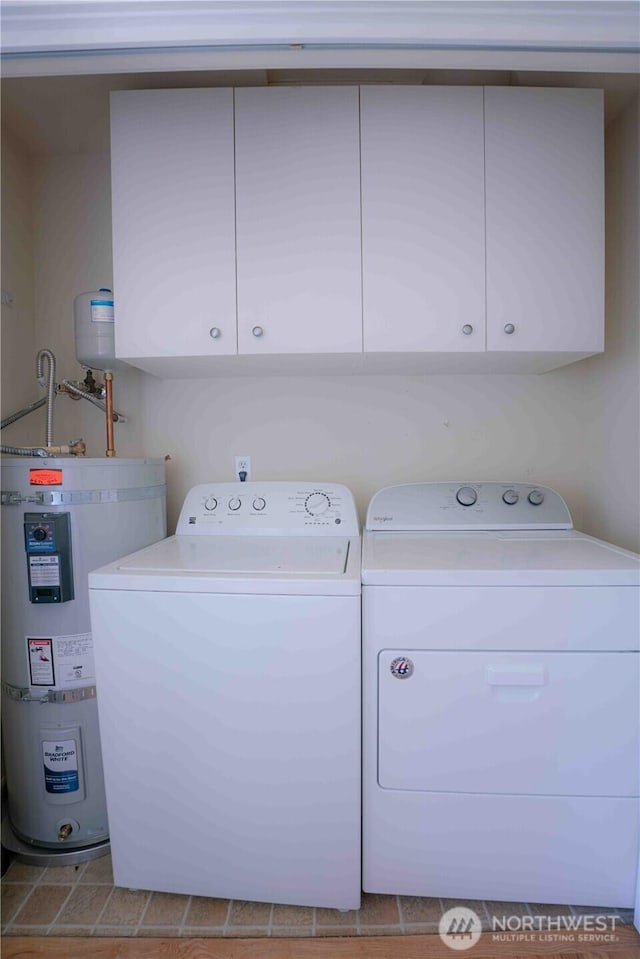 2078 11th St, Port Townsend, WA 98368 - washroom with washing machine and dryer, strapped water heater, and cabinet space