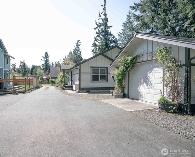 2078 11th St, Port Townsend, WA 98368 - view of front of home featuring board and batten siding, concrete driveway, a garage, and fence