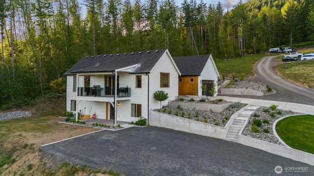 5601 Lewis River Rd, Ariel, WA 98603 - view of front of property featuring driveway, a balcony, a forest view, and roof with shingles