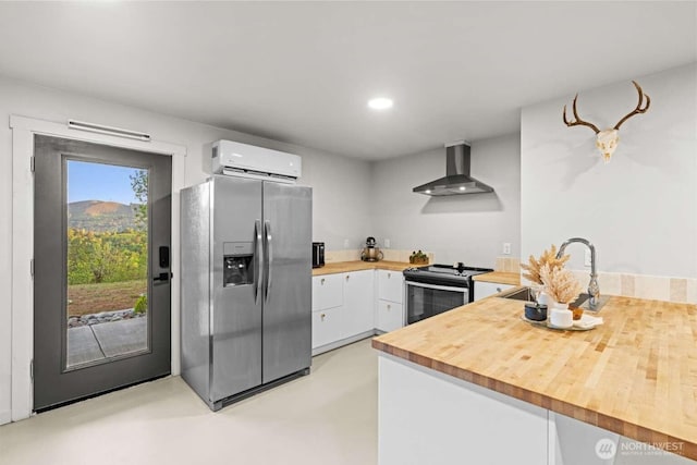 5601 Lewis River Rd, Ariel, WA 98603 - kitchen with appliances with stainless steel finishes, wall chimney range hood, wood counters, a wall mounted air conditioner, and white cabinets