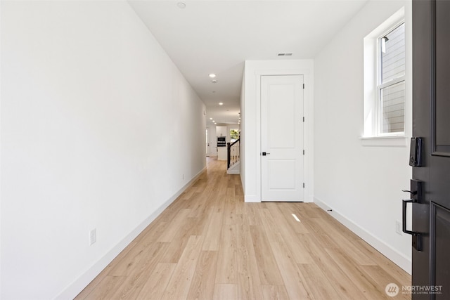 hallway featuring baseboards, recessed lighting, light wood-style flooring, and visible vents
