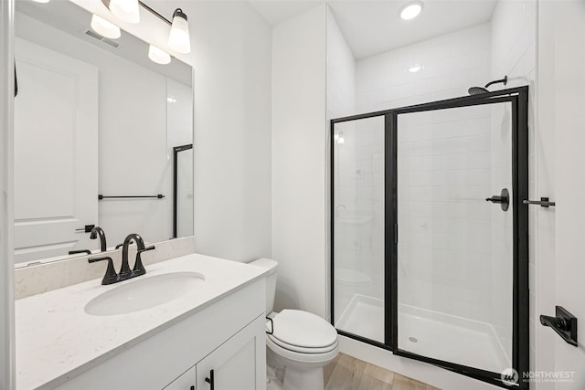 full bathroom featuring a shower stall, toilet, wood finished floors, and visible vents