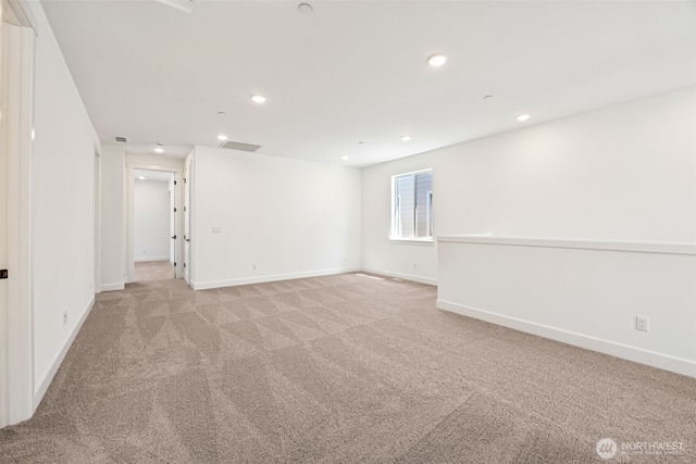 spare room featuring recessed lighting, baseboards, and light carpet