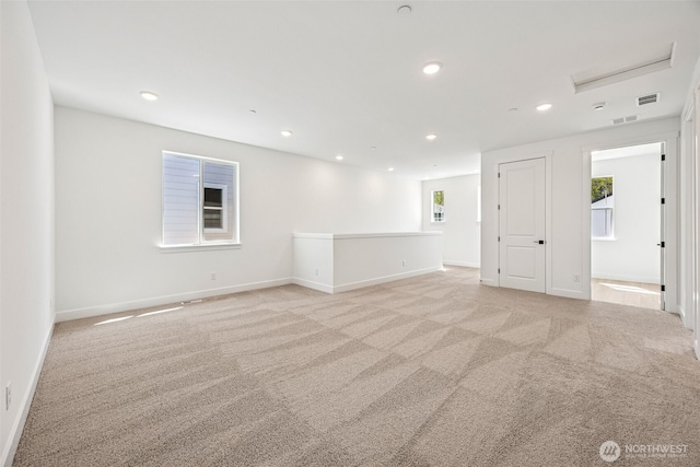empty room featuring light colored carpet, recessed lighting, baseboards, and visible vents