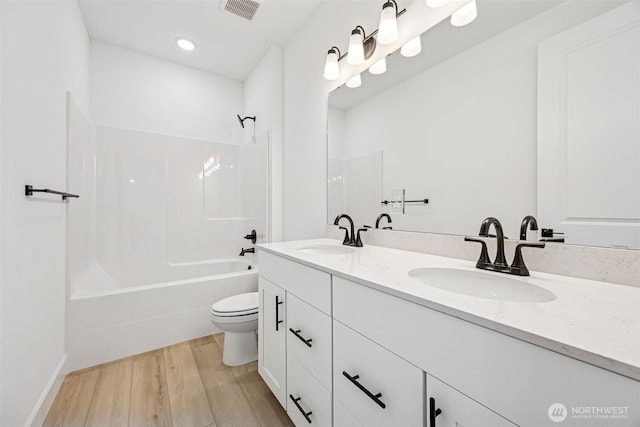 full bath featuring visible vents, a sink, wood finished floors, and toilet