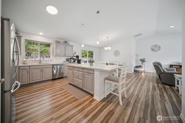 155 Baldwin Ln, Port Ludlow, WA 98365 - kitchen featuring appliances with stainless steel finishes, a sink, gray cabinetry, wood finished floors, and lofted ceiling