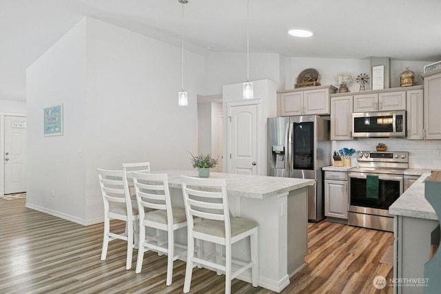155 Baldwin Ln, Port Ludlow, WA 98365 - kitchen featuring stainless steel appliances, light wood-type flooring, light countertops, backsplash, and a center island