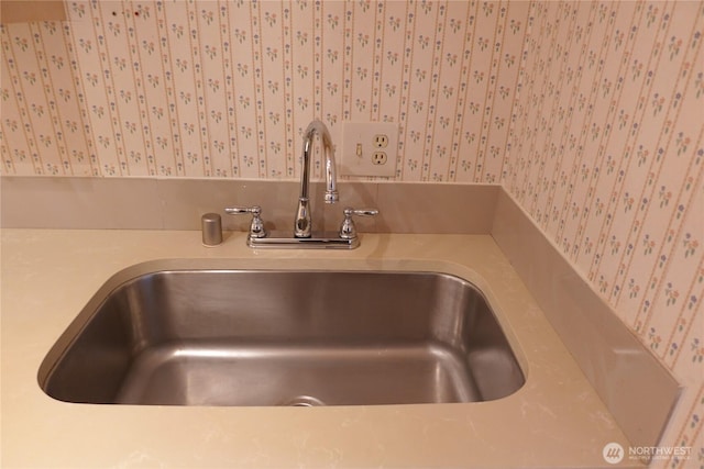 room details with wallpapered walls and a sink