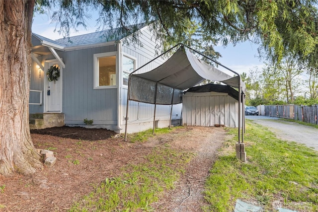 504 107th St S, Tacoma, WA 98444 - view of side of property with dirt driveway, fence, a shingled roof, and a carport