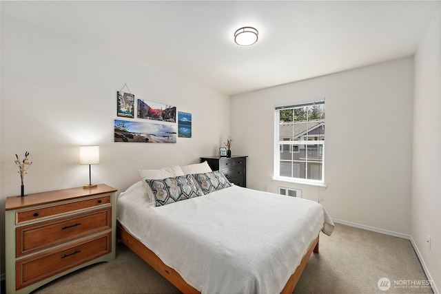 bedroom with light colored carpet and baseboards