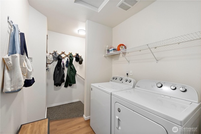 washroom featuring laundry area, visible vents, attic access, washing machine and clothes dryer, and light wood-style flooring