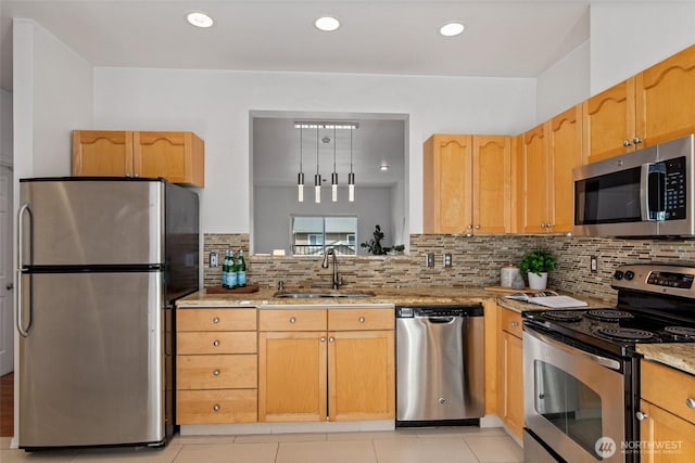 kitchen featuring light tile patterned flooring, light stone countertops, tasteful backsplash, a sink, and stainless steel appliances