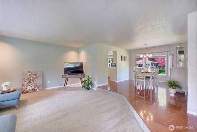 13915 23rd Dr SE, Mill Creek, WA 98012 - carpeted living room featuring a chandelier, a textured ceiling, and baseboards