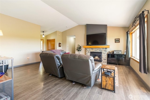 2995 Haynie Rd, Custer, WA 98240 - living room featuring lofted ceiling, wood finished floors, a stone fireplace, and baseboards
