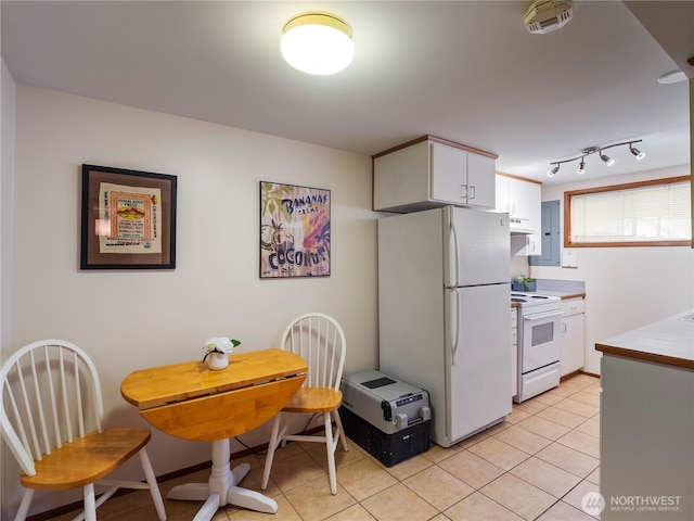 16631 Sylvester Rd SW, Burien, WA 98166 - kitchen with white appliances, light tile patterned floors, under cabinet range hood, light countertops, and white cabinets