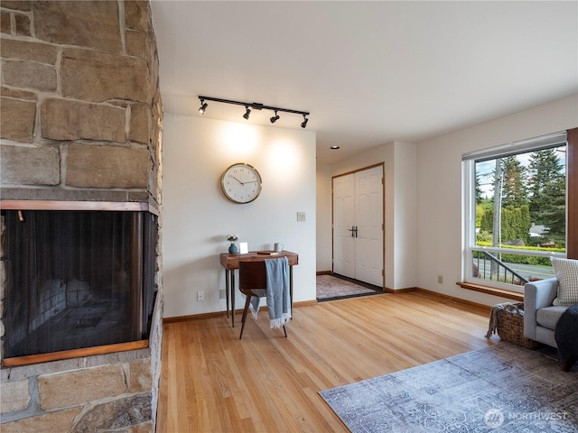 16631 Sylvester Rd SW, Burien, WA 98166 - living room featuring track lighting, baseboards, a fireplace, and wood finished floors