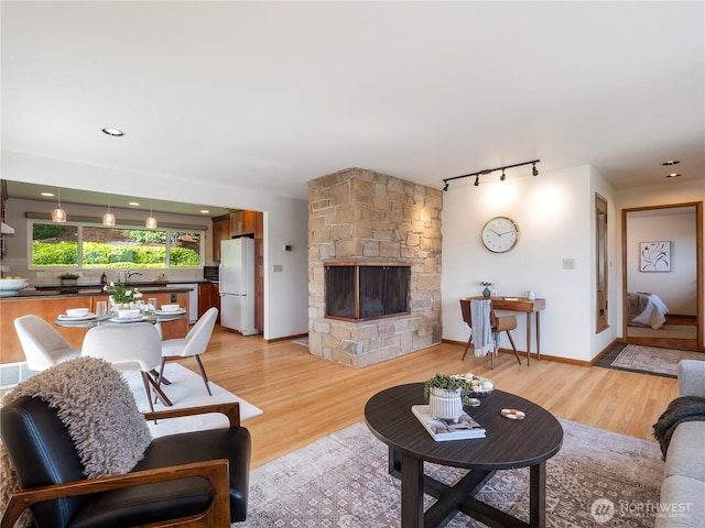 16631 Sylvester Rd SW, Burien, WA 98166 - living room with track lighting, light wood finished floors, and a fireplace