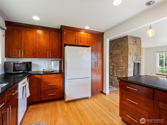 16631 Sylvester Rd SW, Burien, WA 98166 - kitchen with dark stone counters, light wood finished floors, white appliances, and decorative light fixtures