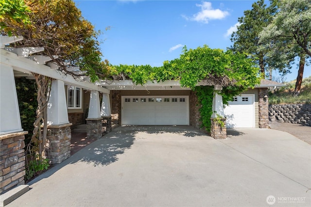 1014 Westmorland Dr, Wenatchee, WA 98801 - view of front facade featuring stone siding, an attached garage, and driveway