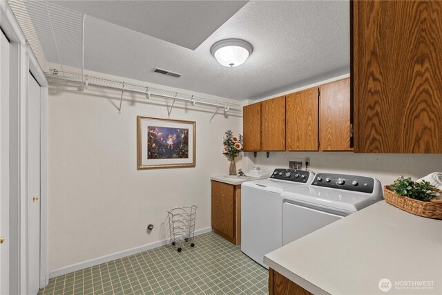 1014 Westmorland Dr, Wenatchee, WA 98801 - laundry area with cabinet space, washer and dryer, baseboards, and a textured ceiling