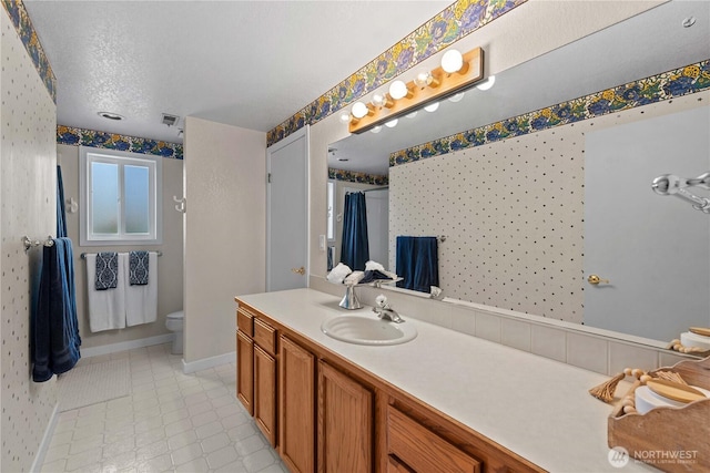 1014 Westmorland Dr, Wenatchee, WA 98801 - full bathroom featuring vanity, toilet, wallpapered walls, baseboards, and a textured ceiling