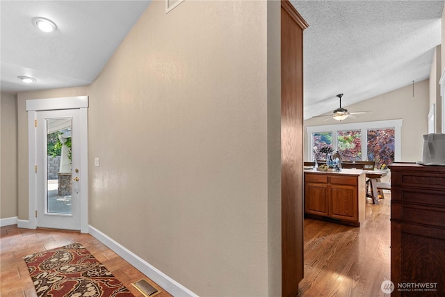 1014 Westmorland Dr, Wenatchee, WA 98801 - foyer entrance featuring lofted ceiling, healthy amount of natural light, a ceiling fan, a textured ceiling, and baseboards