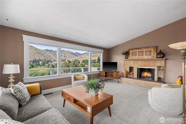 1014 Westmorland Dr, Wenatchee, WA 98801 - carpeted living area with vaulted ceiling, a textured ceiling, a fireplace, and baseboards