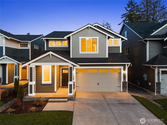 view of front of house featuring a garage, driveway, and stone siding