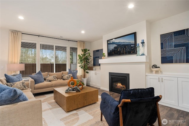 living room featuring light wood-style floors, recessed lighting, and a glass covered fireplace