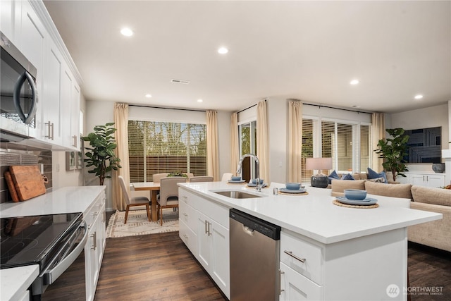 kitchen with visible vents, a sink, light countertops, open floor plan, and stainless steel appliances