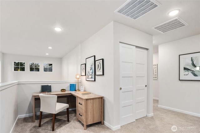 office space with visible vents, baseboards, and light carpet