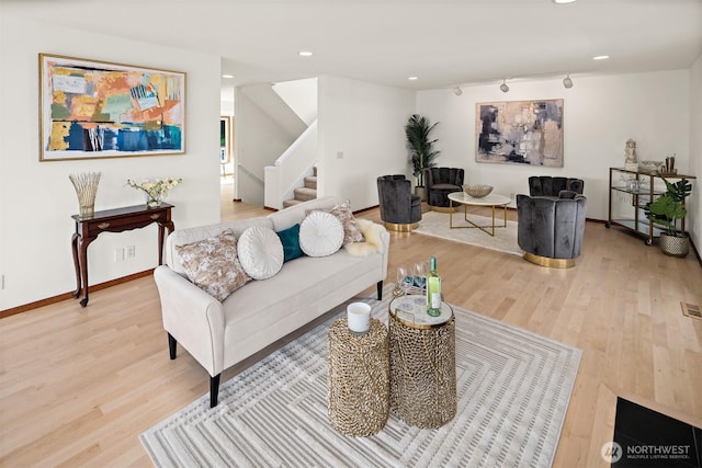 living room featuring light wood finished floors, stairway, baseboards, rail lighting, and recessed lighting