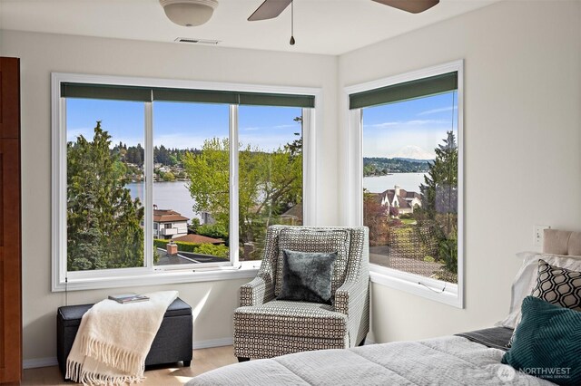 bedroom with a water view and multiple windows